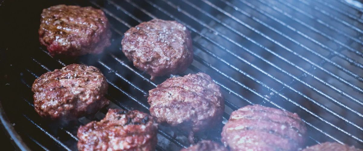 Ground beef patties cooking on a grill