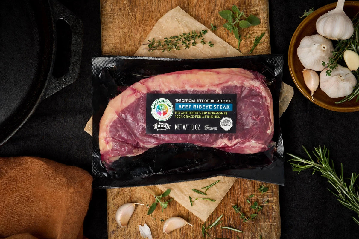 The Paleo Diet grass-fed beef ribeye steak, 10 oz., in packaging with herbs and garlic